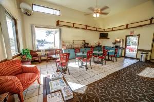 a living room with tables and chairs and a kitchen at River Side Inn New Port Richey in New Port Richey