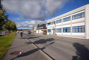 a man riding a bike down a street next to a building at Hotel Svartisen in Mo i Rana