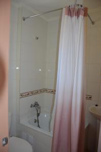 a bathroom with a tub and a shower curtain at Apartamentos Turista in Osorno