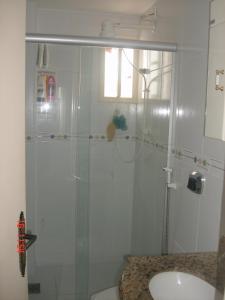 a bathroom with a glass shower and a sink at Casa temporada Peró Cabo Frio in Cabo Frio