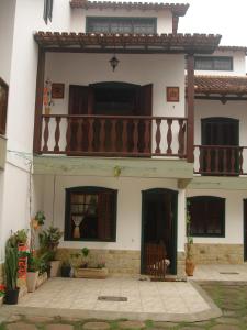 a house with a balcony on the side of it at Casa temporada Peró Cabo Frio in Cabo Frio