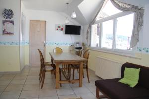 a kitchen and dining room with a table and chairs at Gîte du Belvédère in Gérardmer