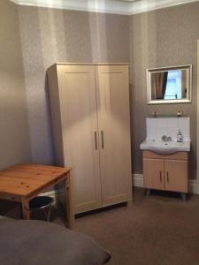 a bathroom with a sink and a cupboard and a sink at Melrose Guest House in Whitley Bay
