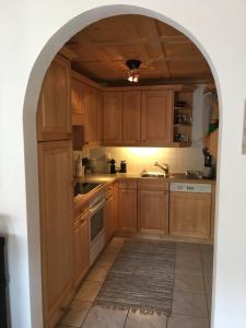 an archway in a kitchen with wooden cabinets at Penthouse Apartment - Sez Ner in Obersaxen