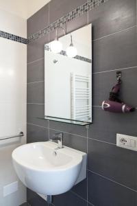 uma casa de banho com um lavatório branco e um espelho. em B&B Petali em Trapani