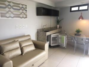 ein Wohnzimmer mit einem Sofa und einer Küche in der Unterkunft Residência Tabatinga in Conde