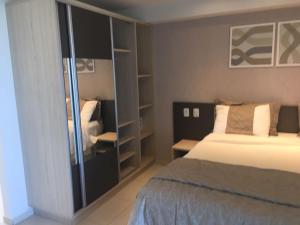 ein Schlafzimmer mit einem Bett und einem Bücherregal in der Unterkunft Residência Tabatinga in Conde