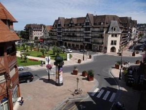 a view of a city with buildings and a parking lot at Le Trophée By M Hôtel Spa in Deauville