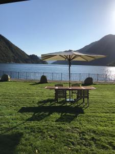 una mesa de picnic con una sombrilla junto a un lago en Sogn Hotel, en Vadheim
