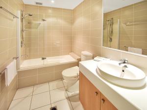 a bathroom with a sink and a toilet and a shower at Bayona Apartments in Noosa Heads