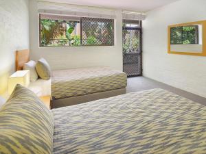 una camera d'albergo con due letti e una finestra di Bayona Apartments a Noosa Heads
