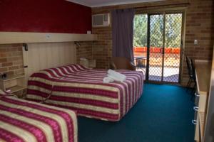 En eller flere senge i et værelse på Windsor Terrace Motel