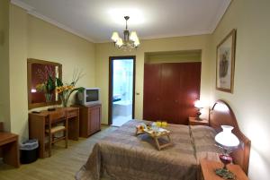 a bedroom with a bed and a television and a table at Villa Elia in Veria