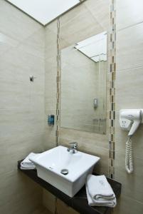 y baño con lavabo y espejo. en Villa Elia, en Veria