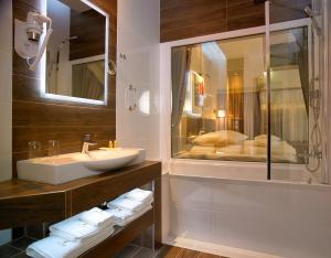 a bathroom with a sink and a shower and a mirror at Aura - Hotel & Restaurant & Sauna in Zielona Góra