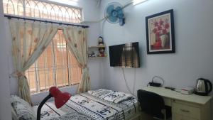 - une chambre avec un lit, un bureau et une fenêtre dans l'établissement Thuy Huong Homestay, à Hô-Chi-Minh-Ville
