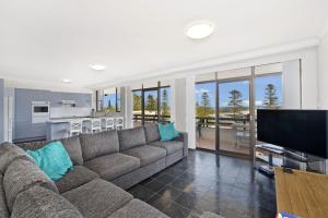 uma sala de estar com um sofá grande e uma cozinha em Akuna 20 6 Joffre Street em Port Macquarie
