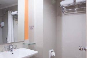 a bathroom with a sink and a mirror at Horison Arcadia Mangga Dua in Jakarta