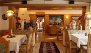 マトライ・アム・ブレンナーにあるホテル シュトルツのテーブルと椅子のあるレストラン、ダイニングルーム