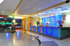 a lobby with a bar with people sitting at it at BP Grand Suite Hotel in Hat Yai