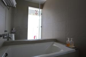 een badkamer met een groot bad en een spiegel bij Ming Yuan B&B in Wujie
