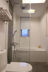 een badkamer met een douche, een toilet en een wastafel bij Ming Yuan B&B in Wujie