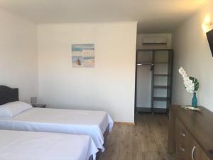 a bedroom with two beds and a vase of flowers at Vila Natalia in Vama Veche