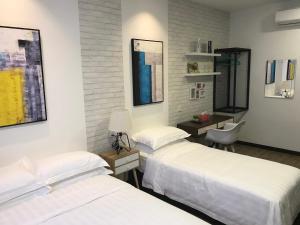 a room with three beds and a desk with a chair at W boutique 10pax with family karaoke in Ipoh