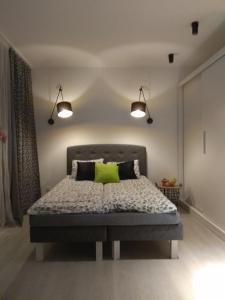 ein Schlafzimmer mit einem Bett mit zwei Leuchten darüber in der Unterkunft Apartament Nikola in Warschau