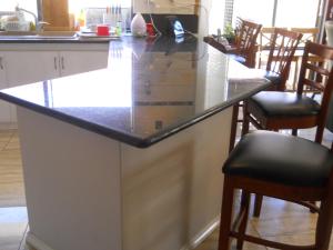 a kitchen with a counter top and some chairs at Mimi's House in Perth