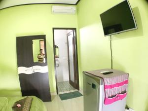 een kamer met een tv aan de muur en een badkamer bij Tegal Homestay in Sanur