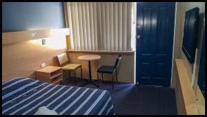 a hotel room with a bed and a table and chairs at Windsor Motel in Windsor