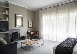 a bedroom with a bed and a living room with a fireplace at Lancemore Lindenderry Red Hill in Red Hill