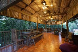 ein Restaurant mit einem Tisch und Stühlen auf einer Terrasse in der Unterkunft Plantacion Isabelle in Taal