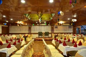a banquet hall with white tables and chairs at Asia Spa Resort in Dharamshala