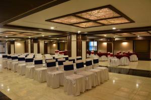 a banquet hall with white chairs and tables at The Suncity in Bhubaneshwar