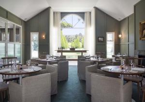 a restaurant with tables and chairs and a window at Lancemore Lindenderry Red Hill in Red Hill