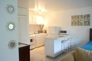 a kitchen with white cabinets and a counter top at One Love Cozy Studio Seawind On The Bay in Montego Bay