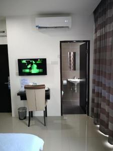 a bathroom with a television and a sink in a room at Comfort Inn in Sibu