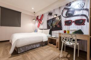 a hotel room with a bed and a desk with a desk at The Young Hotel in Zhongli