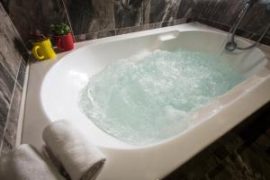 a bath tub filled with green water in a bathroom at The Young Hotel in Zhongli +43 photos