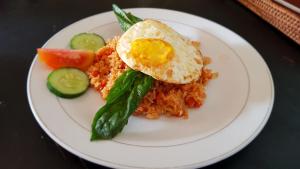 a plate of food with rice and an egg on top at Kencana Garden in Nusa Lembongan