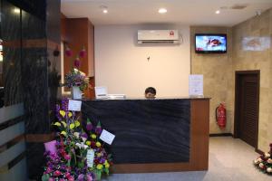 a woman sitting at a reception desk in a flower shop at KL Hotel in Labuan