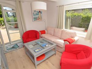 オストゼーバート・ゼリンにあるBlaues Strandhaus Sellinのリビングルーム(赤い椅子、ソファ付)
