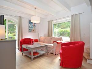 オストゼーバート・ゼリンにあるBlaues Strandhaus Sellinのリビングルーム(赤い椅子、テーブル付)