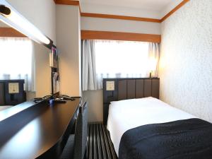 a bedroom with a desk with a bed and a desk at APA Hotel Karuizawa Ekimae Karuizawaso in Karuizawa