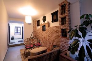 a living room with chairs and a brick wall at Easy Homes - Ashok Stupa in Pātan