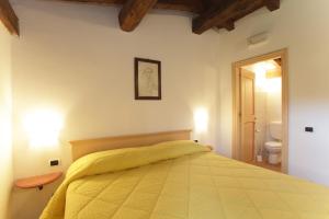 a bedroom with a bed with a yellow blanket at I due Ghiri in Calice al Cornoviglio