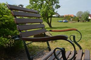 un banco del parque sentado en un campo de hierba en Fachwerkhäuser Gager Valerius, en Gager