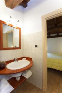 uma casa de banho com um lavatório, um espelho e uma cama em I due Ghiri em Calice al Cornoviglio
